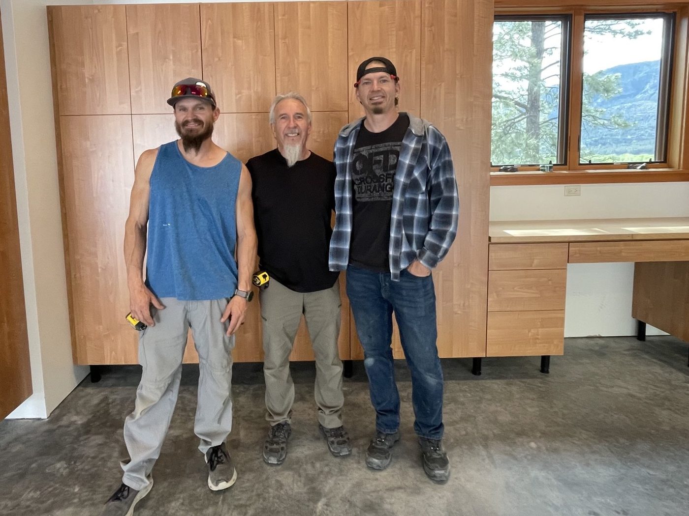 Daniel, Louie and Anthony Valdez standing in front of a finished wall of garage cabinets